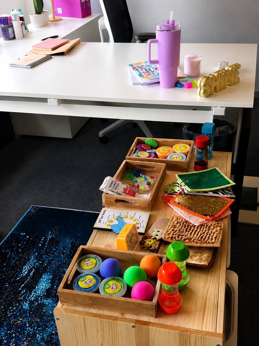 Wooden trays with sensory materials: textured surfaces, balls and sand timers